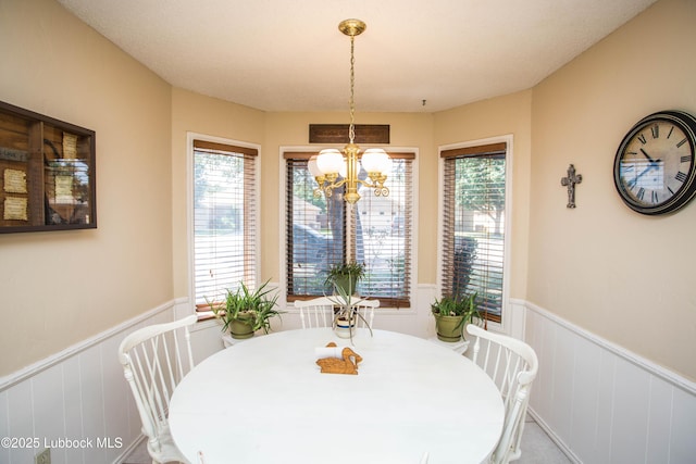 5008 59th St, Lubbock, TX 79414 - dining space featuring a wainscoted wall, a decorative wall, and a chandelier