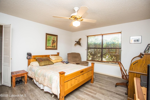 5008 59th St, Lubbock, TX 79414 - bedroom with light wood-style floors, a textured ceiling, and ceiling fan