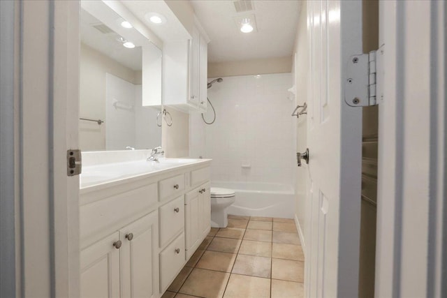 full bathroom with tile patterned flooring, vanity, tiled shower / bath combo, and toilet