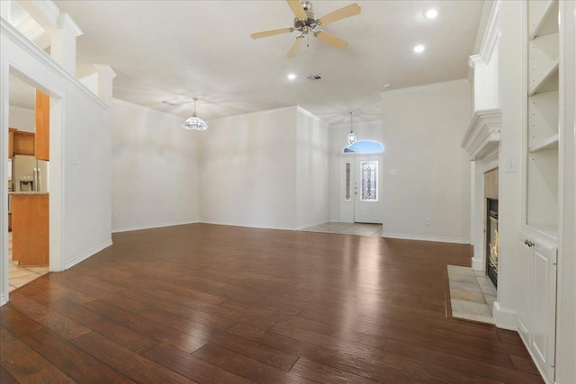 unfurnished living room with dark hardwood / wood-style flooring, ceiling fan with notable chandelier, and ornamental molding