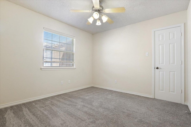 carpeted spare room featuring ceiling fan and a textured ceiling