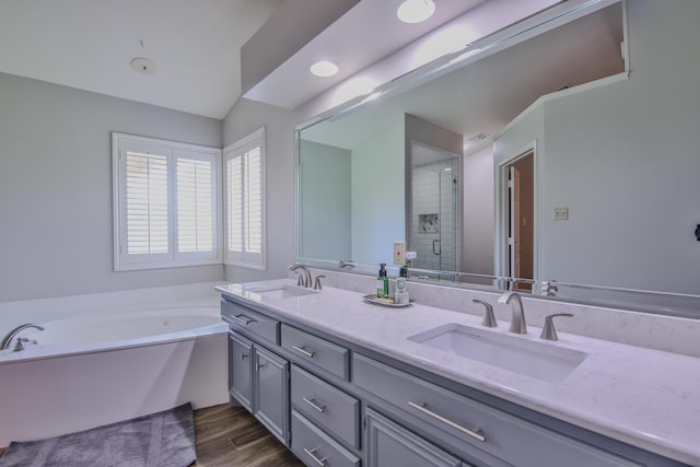 5419 87th St, Lubbock, TX 79424 - bathroom with double vanity, a stall shower, a bath, and wood finished floors