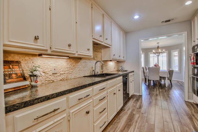 5419 87th St, Lubbock, TX 79424 - kitchen with dark countertops, black dishwasher, a chandelier, backsplash, and light wood finished floors