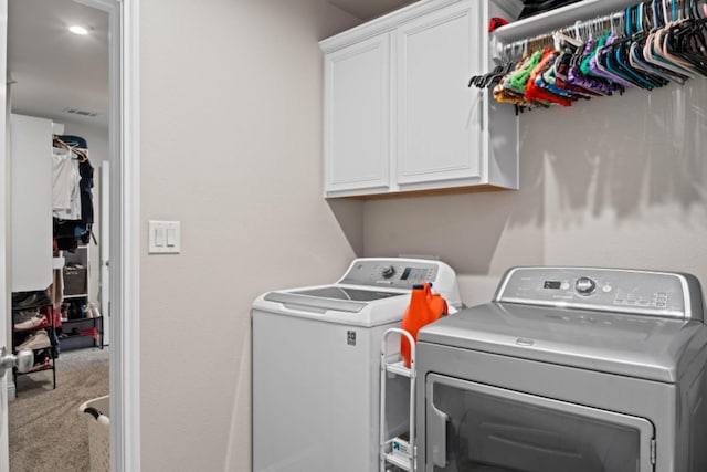 laundry room featuring independent washer and dryer, cabinets, and carpet floors