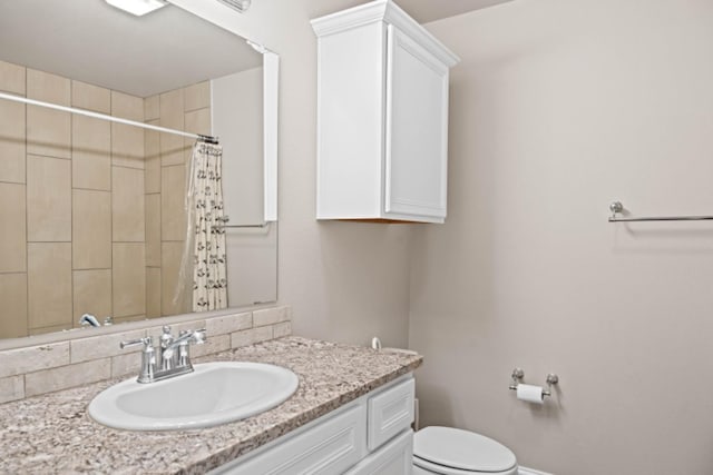 bathroom with vanity, curtained shower, and toilet