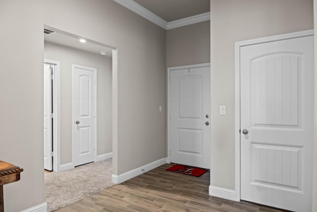 foyer entrance with hardwood / wood-style flooring and crown molding