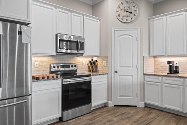 kitchen featuring white cabinetry, stainless steel appliances, dark hardwood / wood-style flooring, and light stone countertops