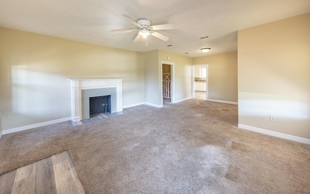 unfurnished living room with ceiling fan, carpet, and a textured ceiling