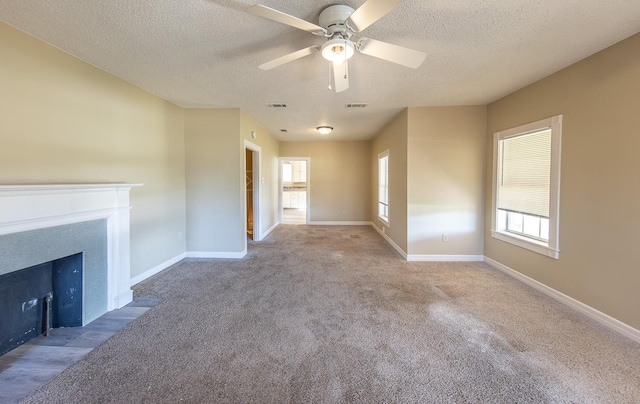 unfurnished living room with ceiling fan, light carpet, and a textured ceiling