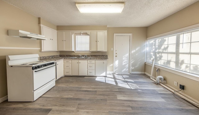 kitchen featuring white cabinetry, sink, light wood-type flooring, white range with electric cooktop, and a textured ceiling