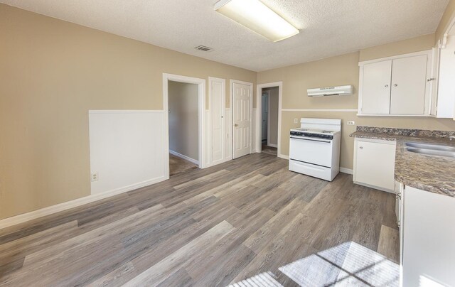 kitchen with sink, white cabinetry, a textured ceiling, light wood-type flooring, and white range with electric stovetop