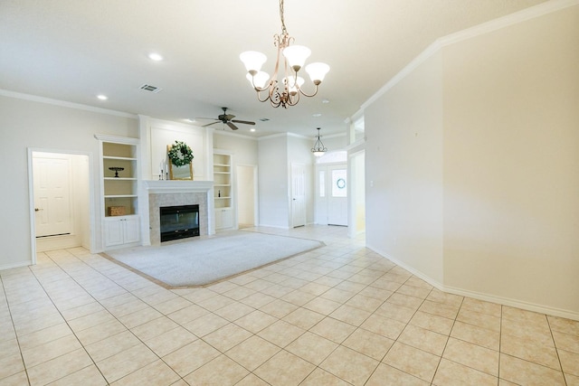 unfurnished living room featuring light tile patterned flooring, ornamental molding, ceiling fan with notable chandelier, and built in features