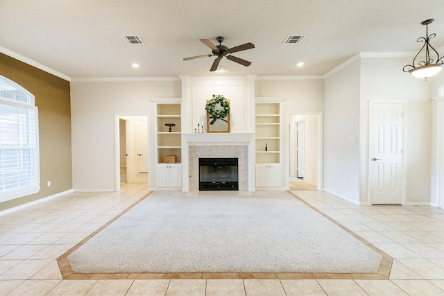 unfurnished living room featuring light tile patterned floors, ornamental molding, built in features, ceiling fan, and a fireplace