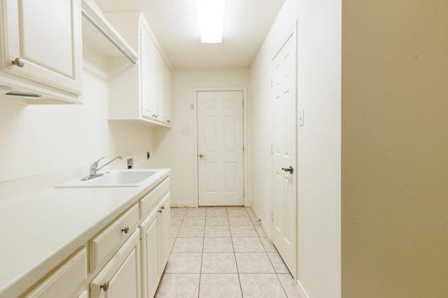 laundry area featuring light tile patterned flooring, sink, cabinets, hookup for a washing machine, and electric dryer hookup