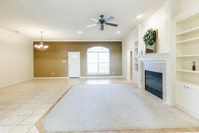 unfurnished living room with built in shelves, ornamental molding, ceiling fan with notable chandelier, and light tile patterned floors