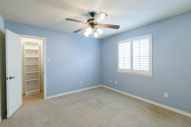 unfurnished room with ceiling fan and a textured ceiling