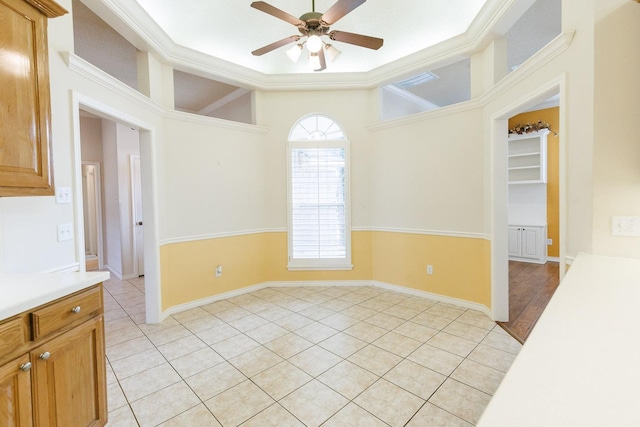 spare room with crown molding, ceiling fan, and light tile patterned floors