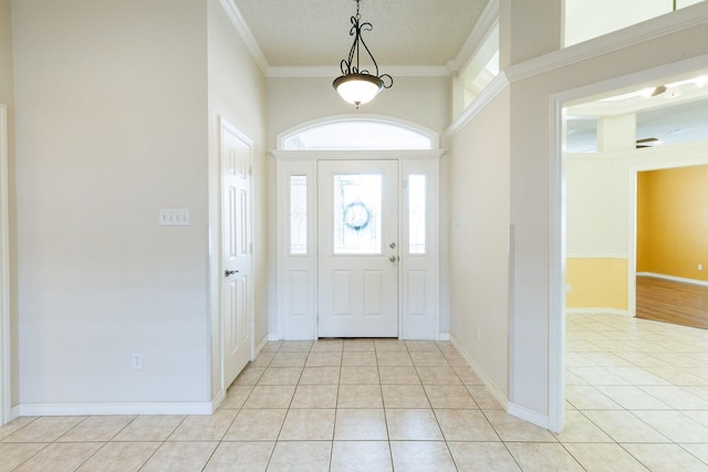 foyer entrance featuring light tile patterned floors, crown molding, and a textured ceiling