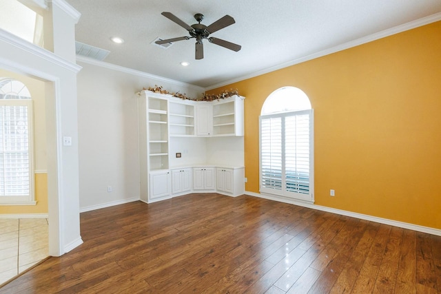 empty room featuring crown molding, dark wood-type flooring, and ceiling fan