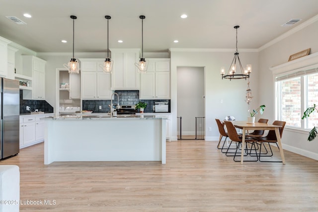 7008 17th St, Lubbock, TX 79416 - kitchen featuring stainless steel refrigerator, a chandelier, decorative backsplash, light wood finished floors, and white cabinets