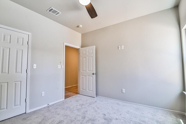 unfurnished bedroom with light carpet and ceiling fan