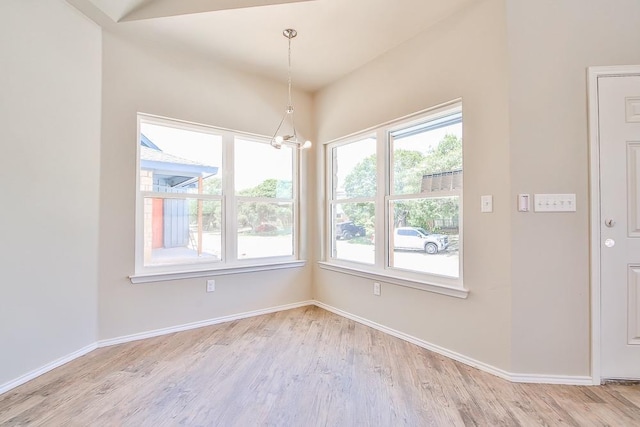 unfurnished dining area featuring a chandelier and light hardwood / wood-style floors