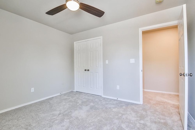 unfurnished bedroom with light carpet, a closet, and ceiling fan