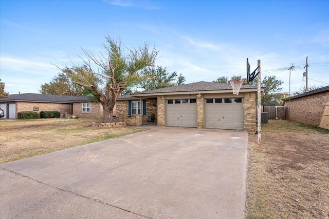 ranch-style house featuring a garage, a front lawn, and central air condition unit