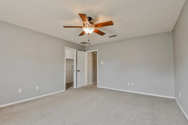 spare room featuring light colored carpet, a textured ceiling, and ceiling fan