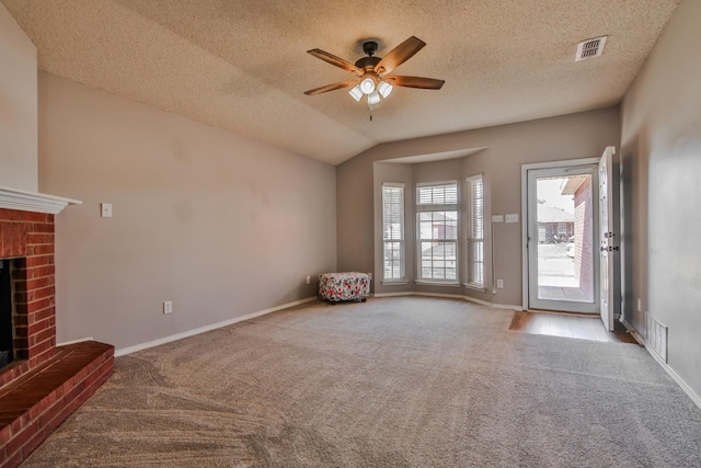 unfurnished living room with light carpet, a brick fireplace, vaulted ceiling, and ceiling fan