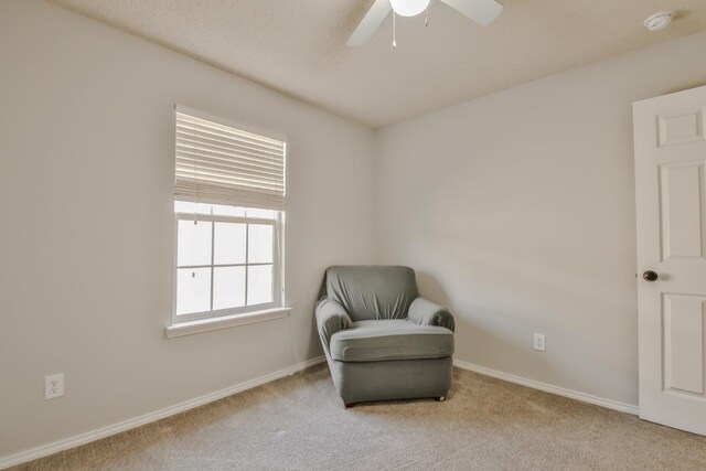 living area featuring light colored carpet and ceiling fan