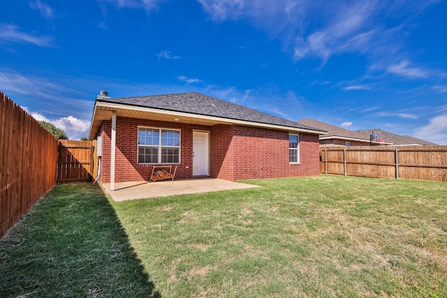 rear view of house featuring a yard and a patio area