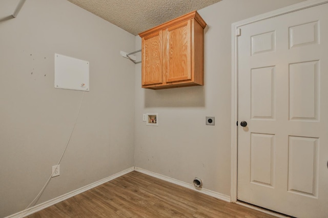 clothes washing area with cabinets, a textured ceiling, washer hookup, hookup for an electric dryer, and hardwood / wood-style floors