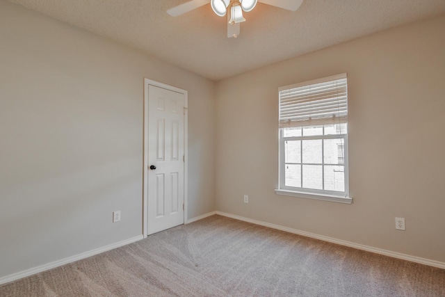 empty room with a textured ceiling, ceiling fan, and carpet