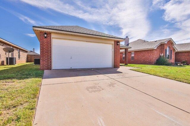 exterior space with cooling unit, a yard, and a garage