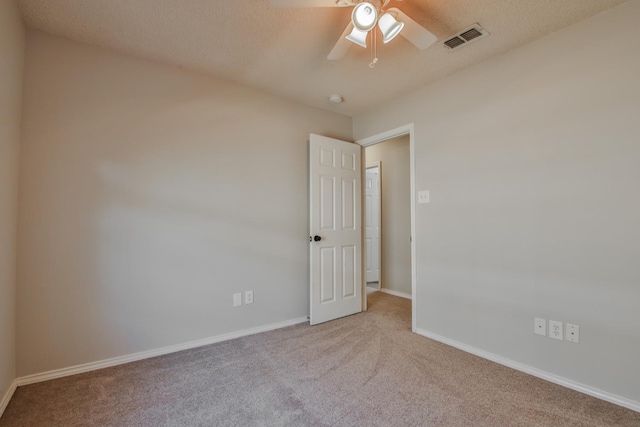 unfurnished room featuring light carpet, a textured ceiling, and ceiling fan