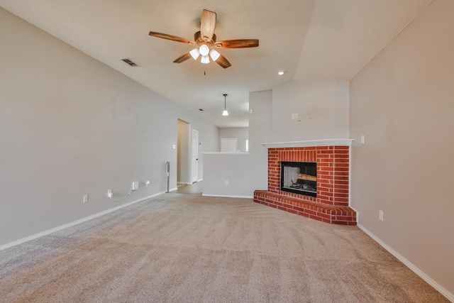 unfurnished living room featuring light carpet, a textured ceiling, a fireplace, and ceiling fan