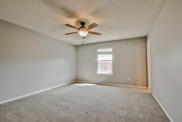 spare room featuring carpet flooring, a textured ceiling, and ceiling fan