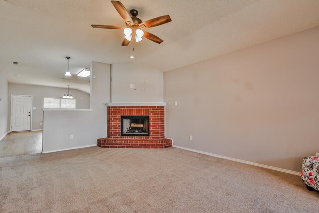 unfurnished living room with vaulted ceiling, a textured ceiling, carpet flooring, ceiling fan, and a fireplace