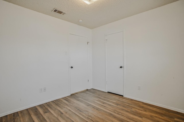 spare room with wood-type flooring and a textured ceiling