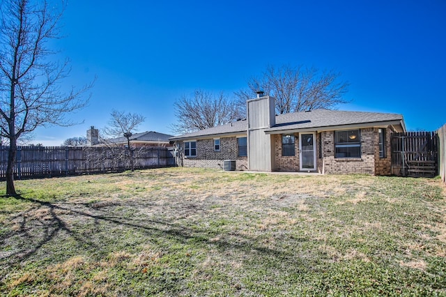 back of property featuring central AC unit and a lawn