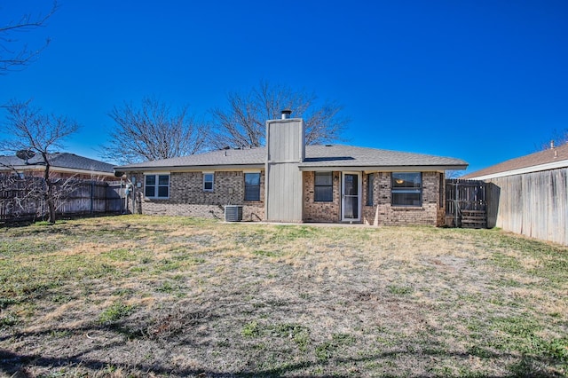 rear view of property featuring a yard and central AC