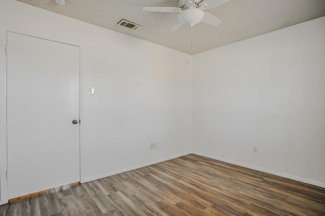 unfurnished room with ceiling fan, dark hardwood / wood-style floors, and a textured ceiling