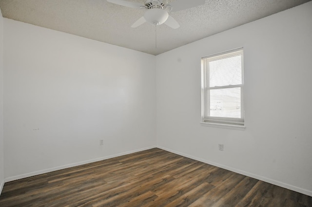 empty room featuring ceiling fan, dark wood-type flooring, and a textured ceiling