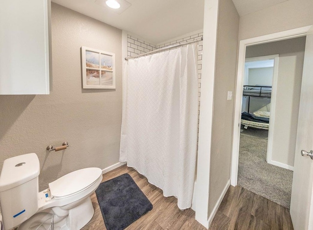 bathroom with hardwood / wood-style flooring, toilet, and a shower with shower curtain