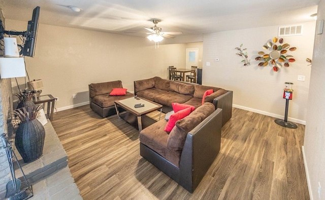 living room featuring wood-type flooring and ceiling fan