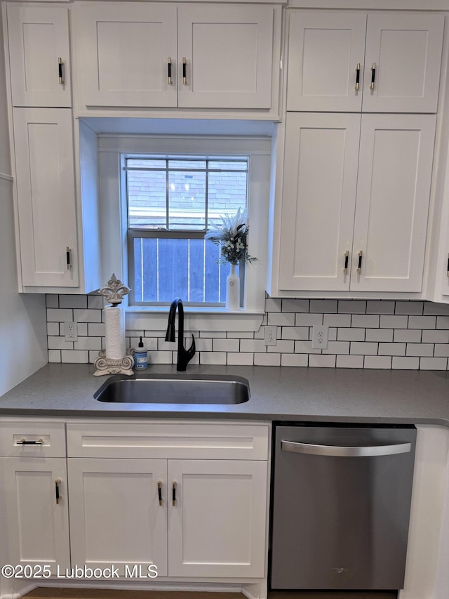 9906 Uvalde Ave, Lubbock, TX 79423 - kitchen featuring stainless steel dishwasher, white cabinetry, decorative backsplash, and dark countertops