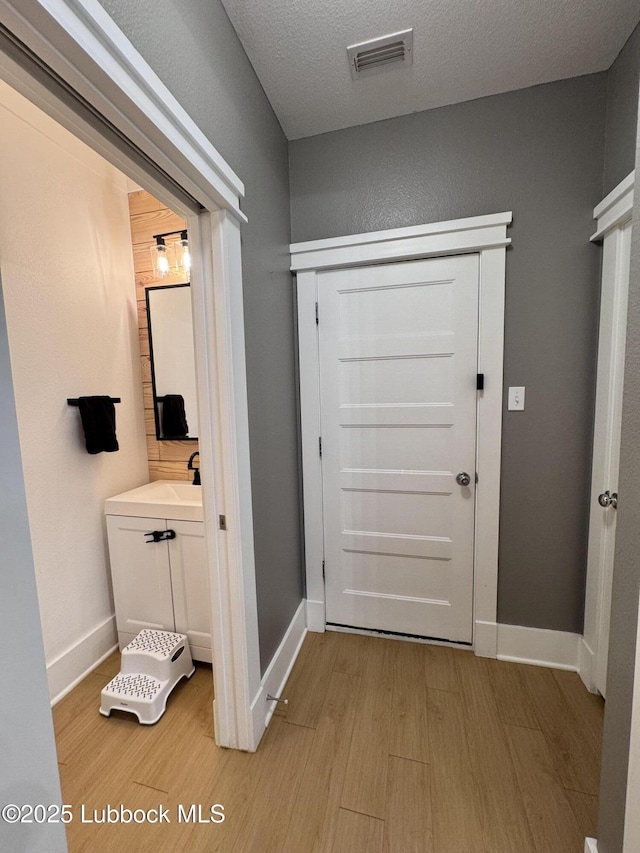 9906 Uvalde Ave, Lubbock, TX 79423 - corridor featuring light wood-style floors and a textured ceiling
