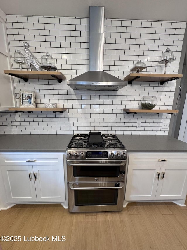 9906 Uvalde Ave, Lubbock, TX 79423 - kitchen featuring range with two ovens, wall chimney exhaust hood, open shelves, and dark countertops