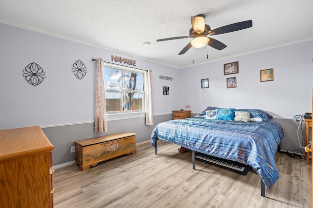 bedroom featuring crown molding, ceiling fan, light hardwood / wood-style flooring, and a textured ceiling